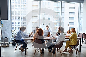 Happy business people gathered around table in office