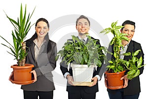 Happy business people holding vases with plants