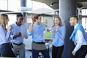 Happy business people laugh in the office. Successful team coworkers joke and have fun together at work.