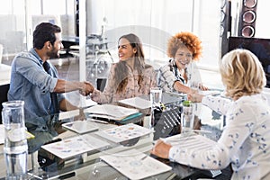 Happy business people shaking hands at creative office