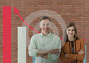 Happy business people standing against brick wall with graphics