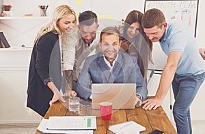 Happy business people team together with laptop in office