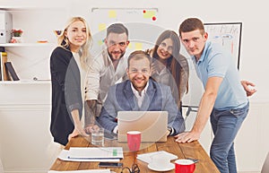 Happy business people team together near laptop in office