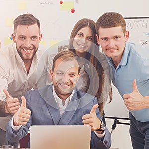 Happy business people team together near laptop in office