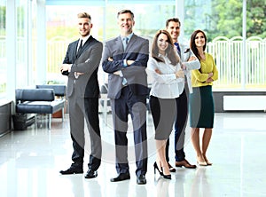 Happy business team with arms crossed at the office.