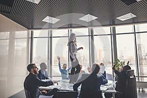 Happy business team celebrating victory in office. woman stand on table
