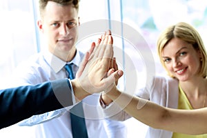 Happy business team giving high five in office