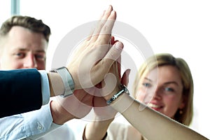 Happy business team giving high five in office