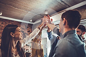 happy business team giving high five in office