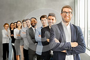 Happy business team headed with boss standing in row
