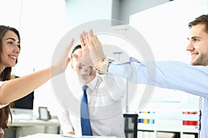Happy business team high five in office
