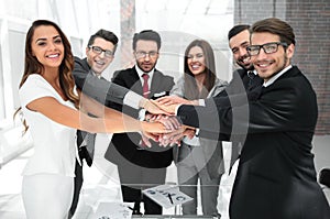 Happy business team joining hands together