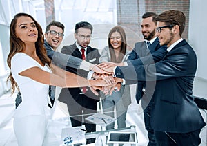 Happy business team joining hands together