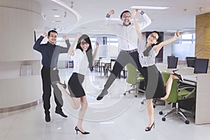 Happy business team jumping in the office