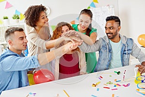 Happy business team at office party holding hands