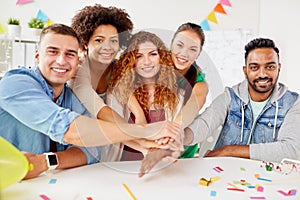 Happy business team at office party holding hands