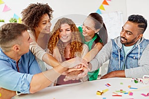 Happy business team at office party holding hands