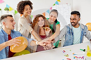 Happy business team at office party holding hands