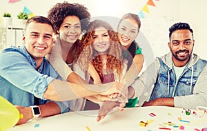 Happy business team at office party holding hands