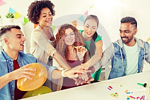 Happy business team at office party holding hands