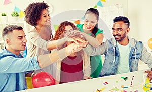 Happy business team at office party holding hands