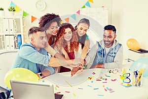 Happy business team at office party holding hands