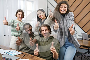 happy business team showing thumbs up. close-up.