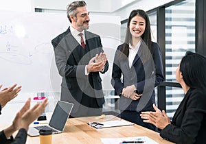 The happy business team smiles and claps to colleagues who present good work