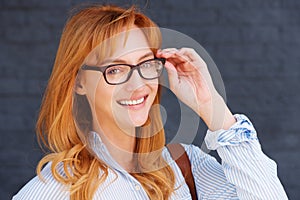 Happy business woman adjusting glasses