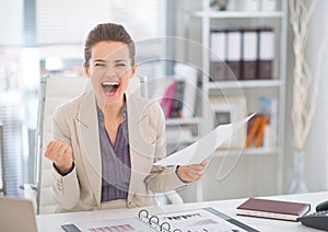 Happy business woman with document rejoicing photo