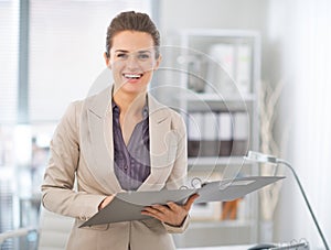 Happy business woman with documents in office