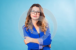 Happy business woman in eyeglasses looking at the camera over blue background