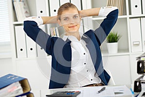 Happy business woman or female accountant having some minutes for coffee and pleasure at working place