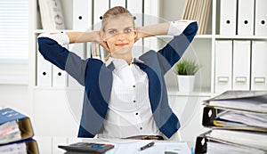 Happy business woman or female accountant having some minutes for coffee and pleasure at working place