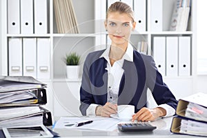 Happy business woman or female accountant having some minutes for coffee and pleasure at working place. Audit and tax