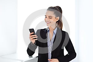 Happy business woman holding mobile phone