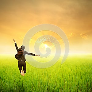 Happy business woman jumping in green rice field