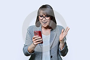 Happy business woman looking at smartphone screen, on white background