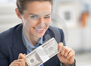 Happy business woman money pack and winking