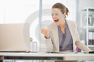 Happy business woman in office rejoicing success photo