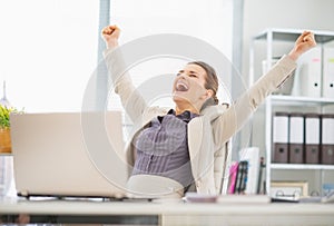 Happy business woman in office rejoicing success photo