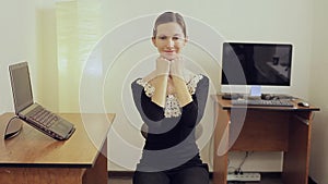 Happy business woman in office stretching her neck while sitting near the desk