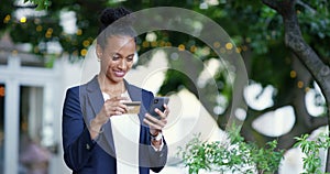 Happy business woman on a phone with her credit card making an online internet bank payment. Lady doing ecommerce