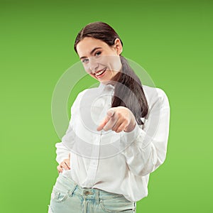 The happy business woman point you and want you, half length closeup portrait on green background.