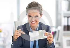 Happy business woman pointing on money pack