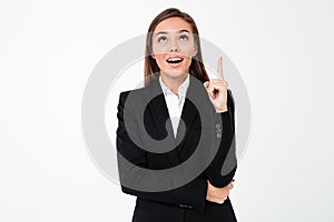 Happy business woman pointing to copyspace.