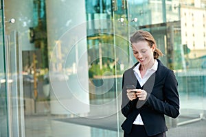 Happy business woman reading text message on mobile phone