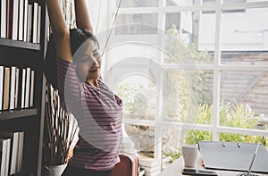 Happy business woman relaxing and stretching out in office