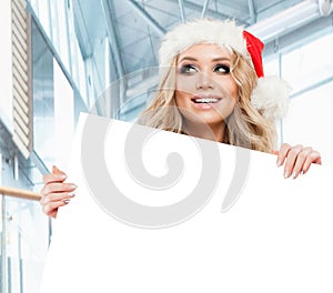 Happy business woman in Santa hat looking up