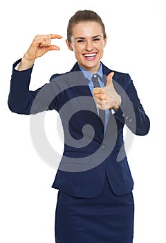 Happy business woman showing small risks gesture and thumbs up